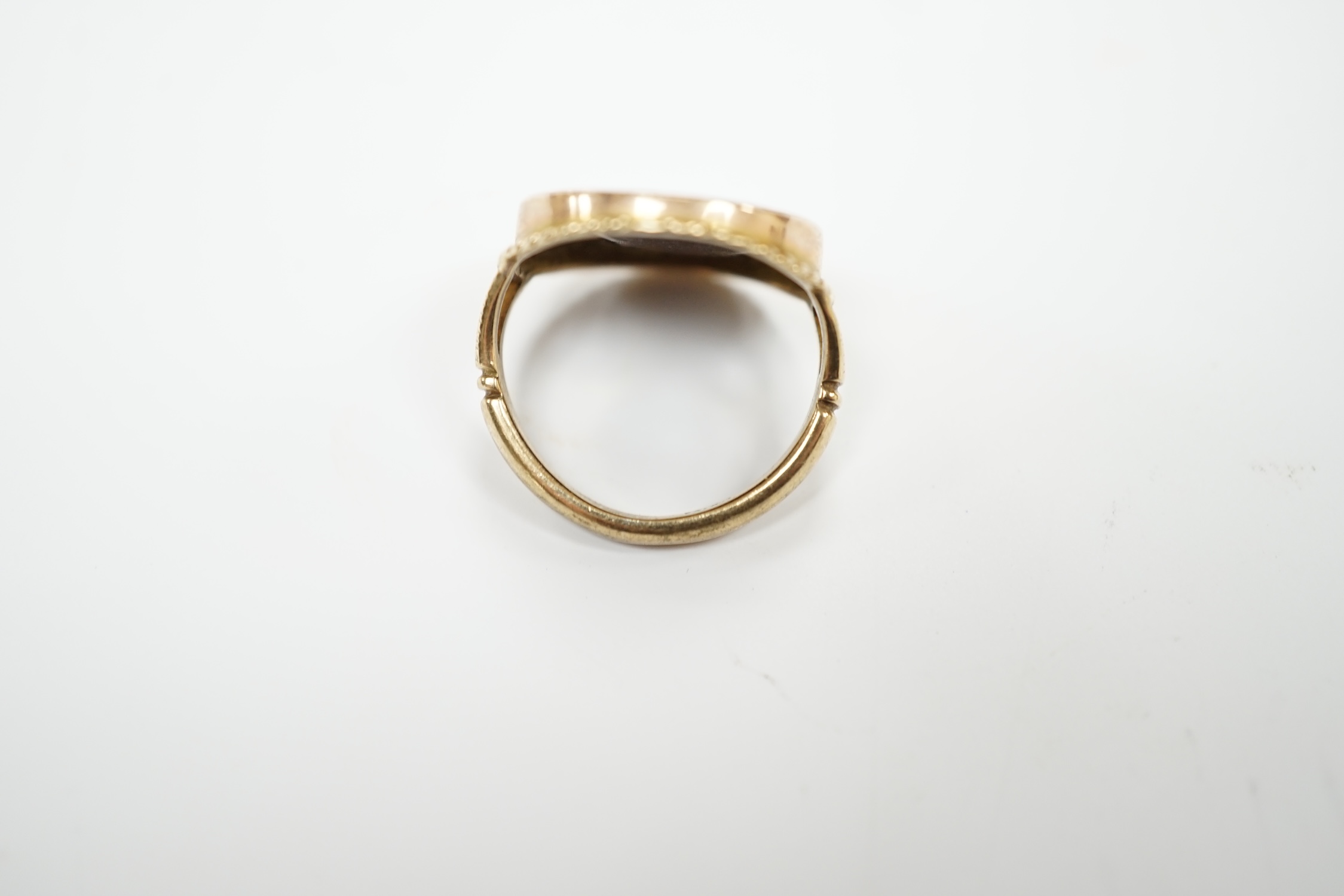 An antique 9ct and enamel set circular ring, depicting the head of a gentleman to dexter, size G, gross weight 3.2 grams.